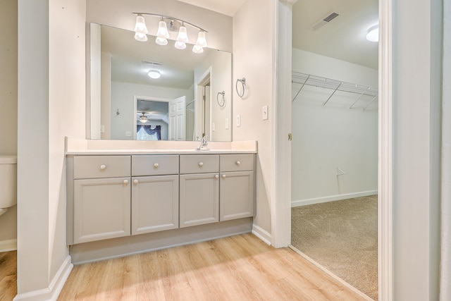 bathroom with wood-type flooring, vanity, and ceiling fan