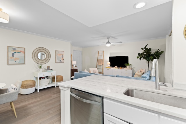 kitchen with sink, crown molding, dishwasher, hardwood / wood-style floors, and light stone counters