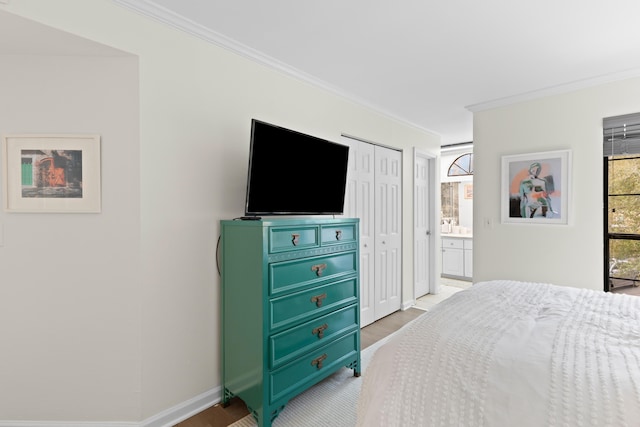 bedroom with ornamental molding, ensuite bathroom, light hardwood / wood-style floors, and a closet