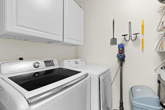 clothes washing area featuring cabinets and independent washer and dryer