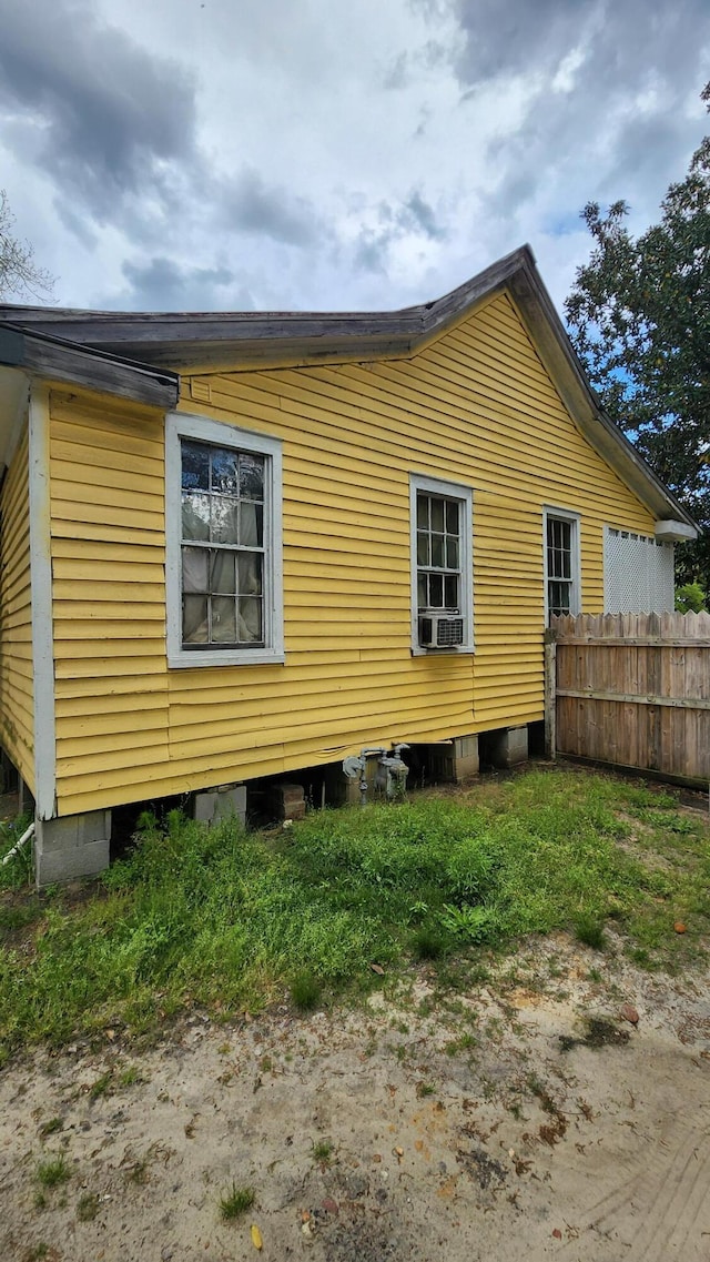 view of side of property with fence and cooling unit