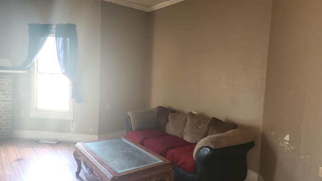 living room with baseboards, ornamental molding, and wood finished floors