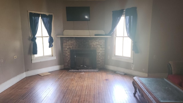 living room with a fireplace, baseboards, wood finished floors, and plenty of natural light