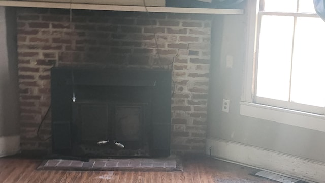 room details featuring a brick fireplace and wood finished floors