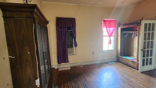 unfurnished bedroom featuring baseboards, wood finished floors, and ornamental molding
