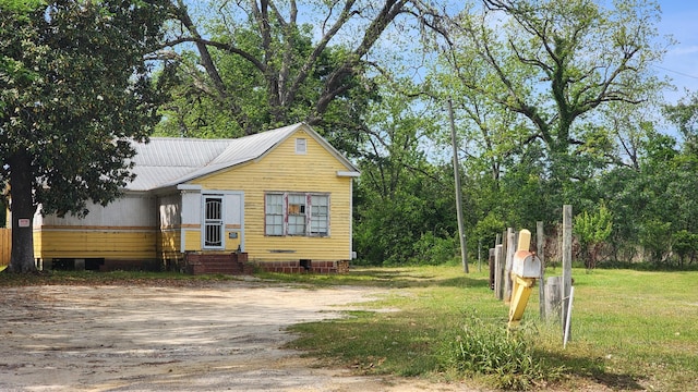 bungalow-style house featuring crawl space, a front lawn, and metal roof