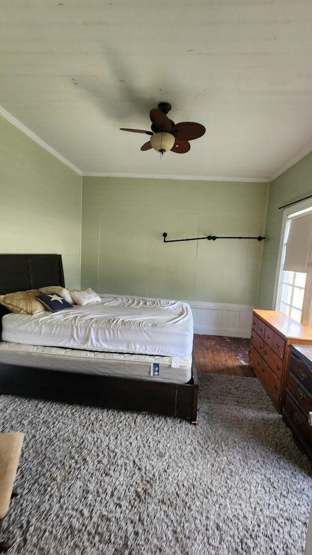 carpeted bedroom featuring a ceiling fan and ornamental molding