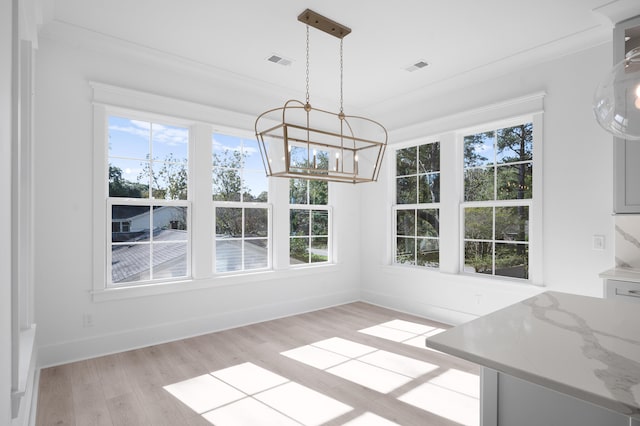 unfurnished dining area with a notable chandelier and light hardwood / wood-style floors