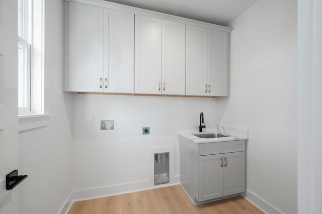 laundry room featuring cabinets, sink, hookup for a washing machine, hookup for an electric dryer, and light hardwood / wood-style floors