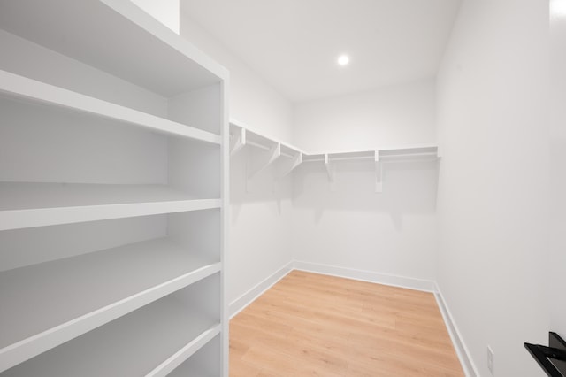 walk in closet with hardwood / wood-style flooring