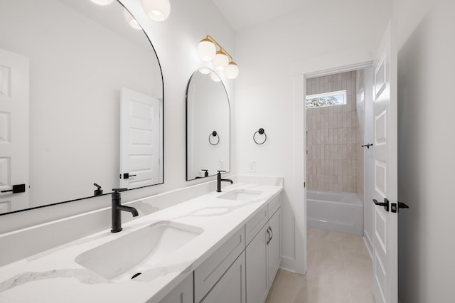 bathroom with tile patterned flooring, vanity, and tiled shower / bath