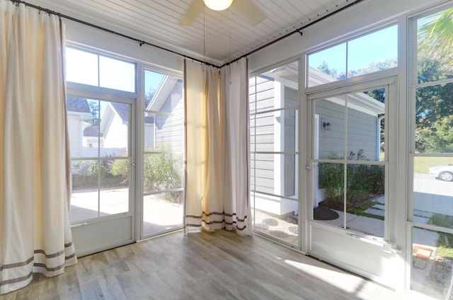 doorway to outside with a ceiling fan, plenty of natural light, and wood finished floors