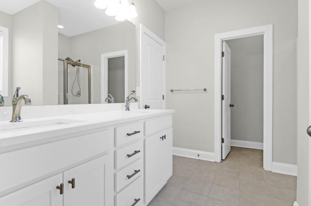 bathroom featuring double vanity, a sink, tile patterned floors, and a shower stall