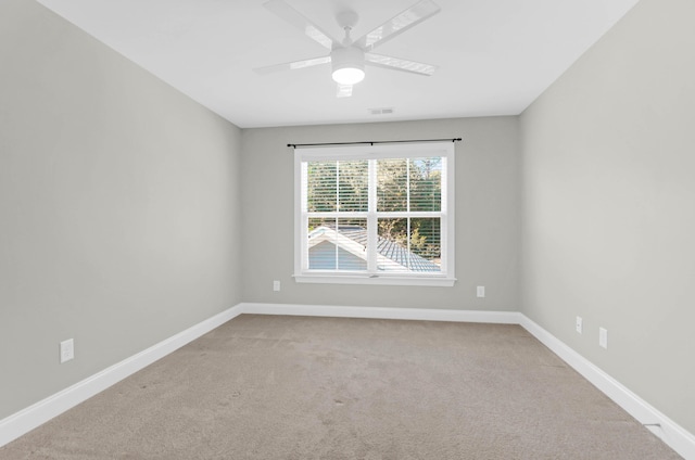 carpeted empty room featuring a ceiling fan, baseboards, and visible vents