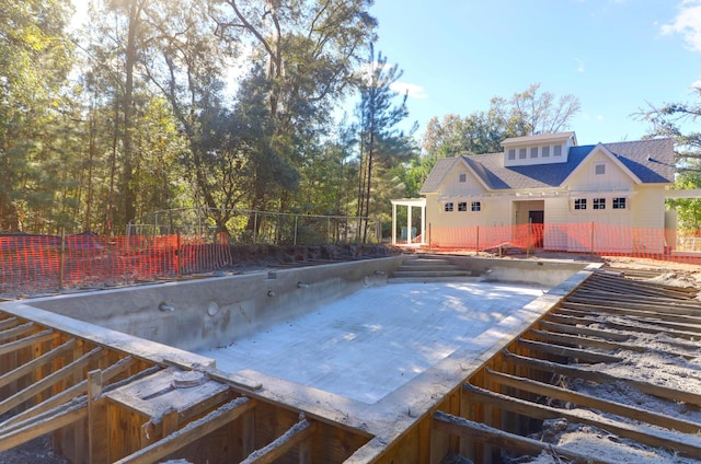 view of swimming pool featuring fence and a deck