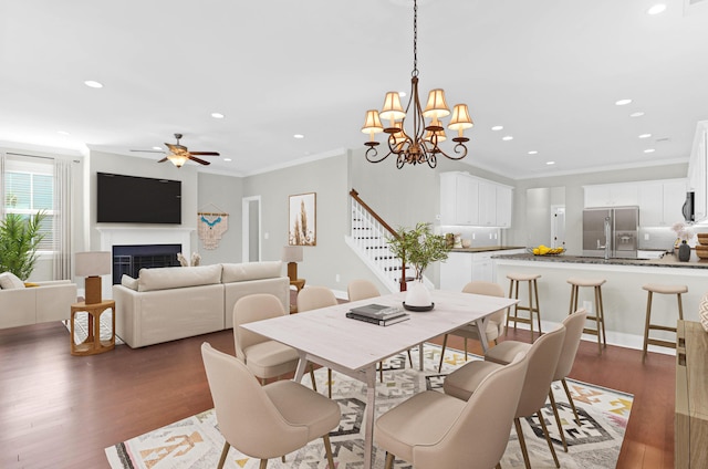 dining room with crown molding, stairway, ceiling fan with notable chandelier, recessed lighting, and dark wood-type flooring