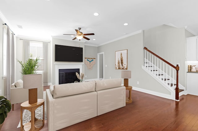 living room with crown molding, ceiling fan, and wood finished floors
