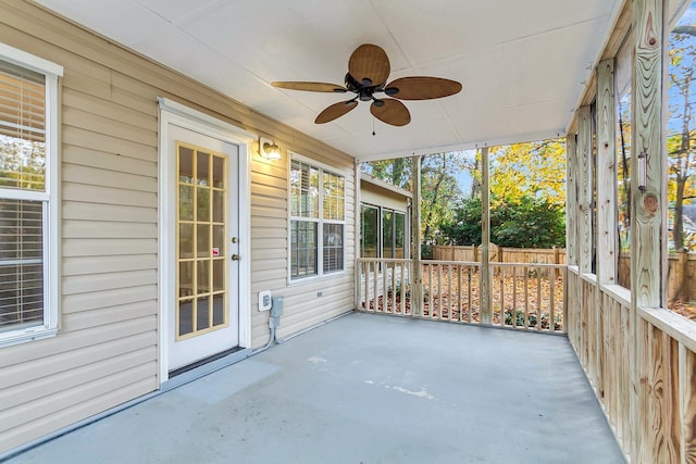 unfurnished sunroom featuring ceiling fan