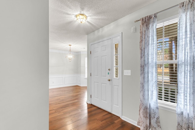 foyer featuring a textured ceiling, dark hardwood / wood-style flooring, and plenty of natural light