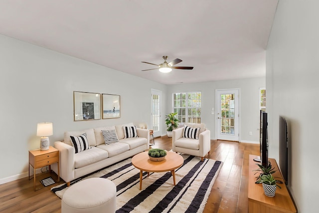 living room featuring ceiling fan and hardwood / wood-style flooring