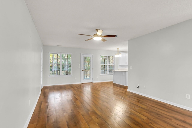 unfurnished living room with ceiling fan and wood-type flooring