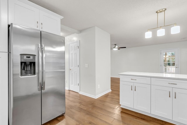 kitchen featuring ceiling fan, hanging light fixtures, stainless steel refrigerator with ice dispenser, light hardwood / wood-style floors, and white cabinets