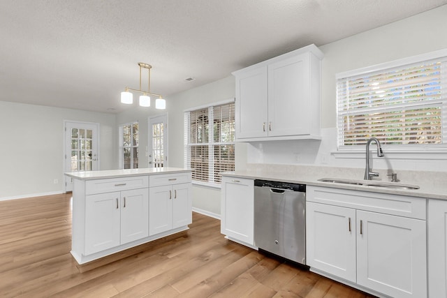 kitchen featuring dishwasher, white cabinets, decorative light fixtures, and sink