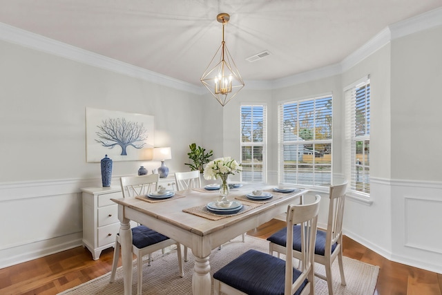 dining room featuring crown molding, a chandelier, and hardwood / wood-style flooring