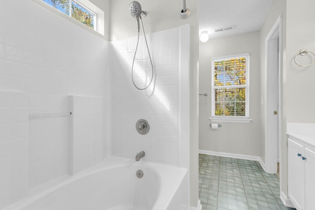 bathroom featuring vanity, a textured ceiling, and bathing tub / shower combination