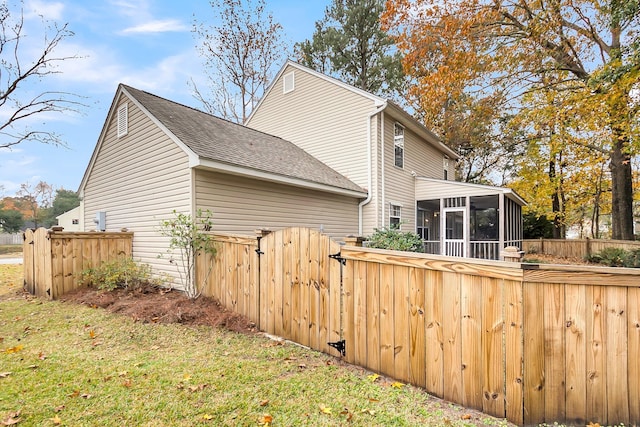 view of home's exterior featuring a sunroom and a yard