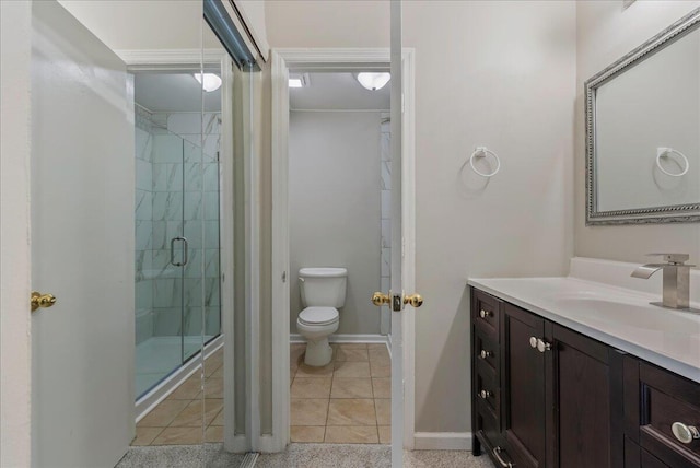 bathroom with tile patterned flooring, vanity, a shower with shower door, and toilet