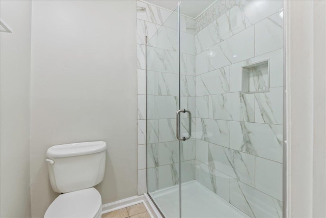 bathroom featuring tile patterned flooring, toilet, and a shower with door