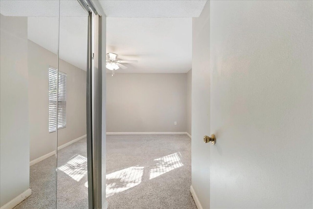 carpeted spare room featuring ceiling fan