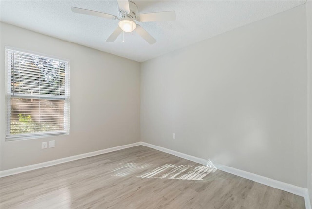 spare room featuring ceiling fan, light wood-type flooring, and a textured ceiling