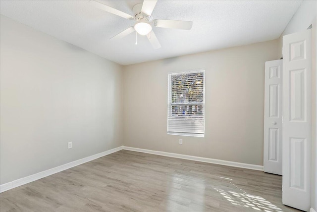 unfurnished bedroom featuring ceiling fan, light wood-type flooring, and a textured ceiling