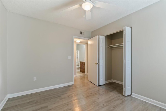 unfurnished bedroom with a textured ceiling, a closet, light hardwood / wood-style flooring, and ceiling fan