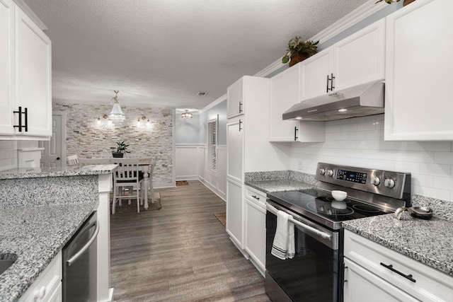 kitchen with dark hardwood / wood-style floors, white cabinets, hanging light fixtures, stainless steel appliances, and a textured ceiling