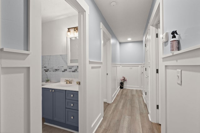 hallway featuring sink and light hardwood / wood-style floors