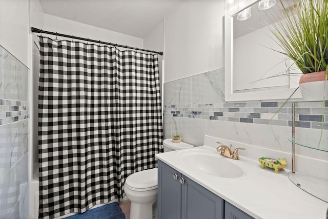 bathroom featuring vanity, toilet, tile walls, and a textured ceiling