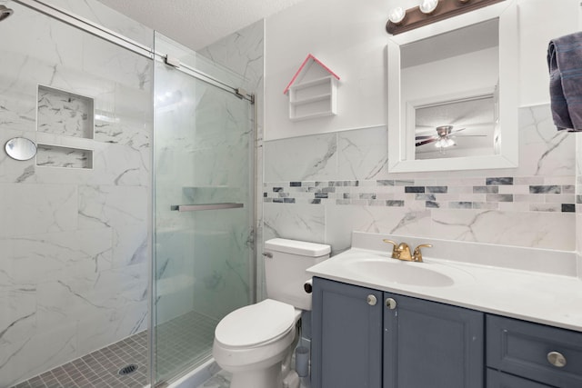 bathroom with toilet, a shower with shower door, a textured ceiling, tile walls, and vanity