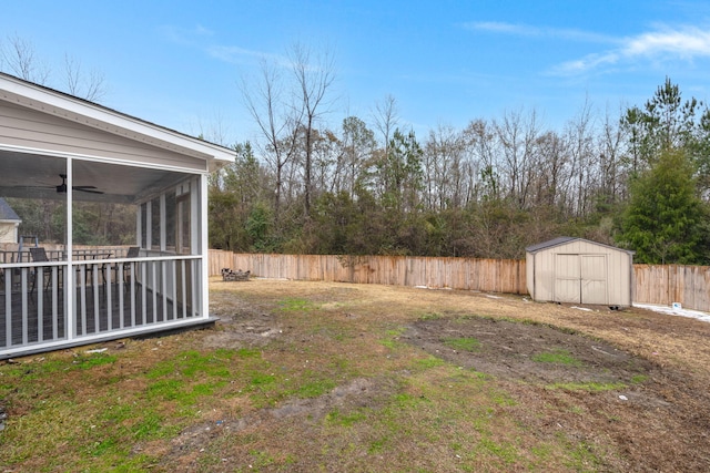 view of yard with a shed, a sunroom, and ceiling fan