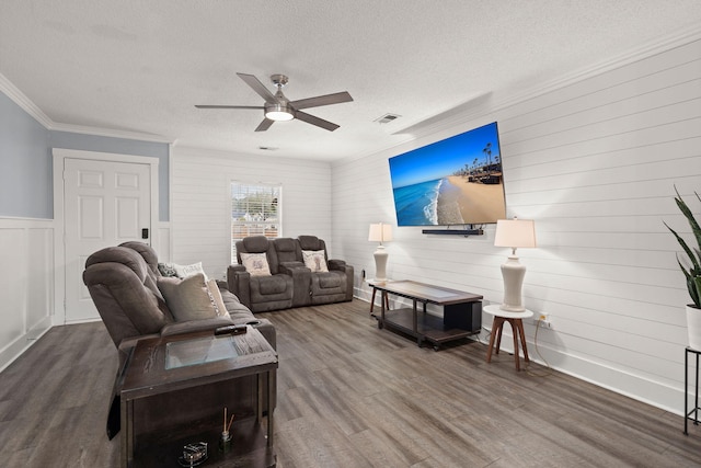 living room with hardwood / wood-style flooring, ceiling fan, ornamental molding, and a textured ceiling