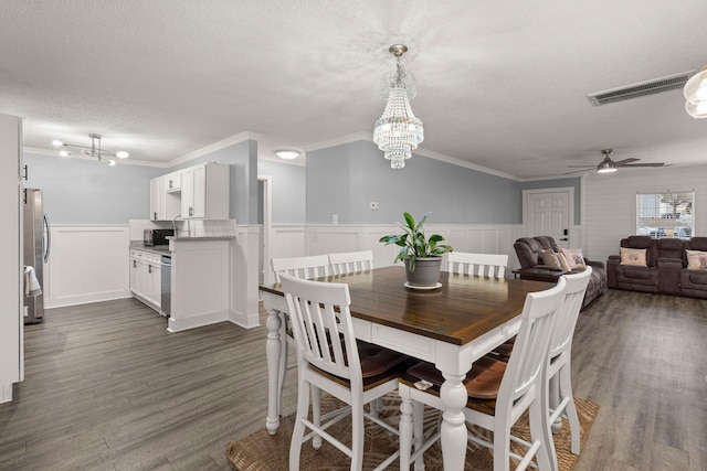 dining area with dark hardwood / wood-style flooring, ornamental molding, ceiling fan with notable chandelier, and a textured ceiling