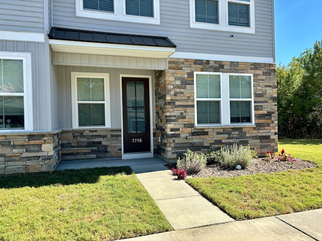 view of exterior entry with a lawn