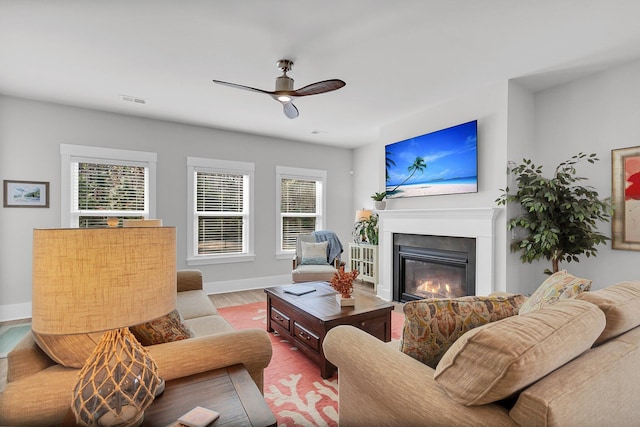 living room with ceiling fan, plenty of natural light, and light hardwood / wood-style flooring