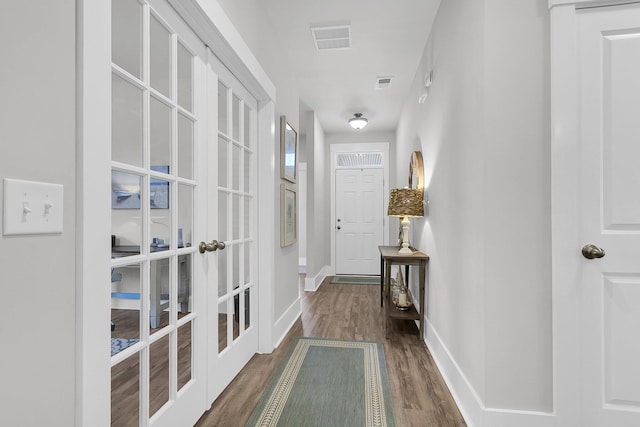 hall with dark hardwood / wood-style floors and french doors