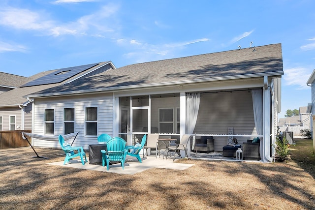 back of house with a sunroom, a patio area, and a lawn