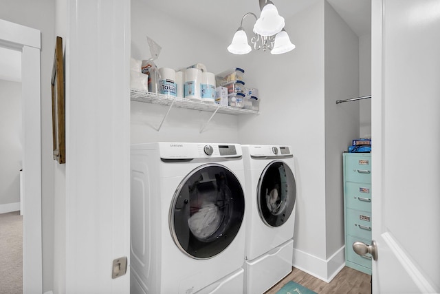 laundry area featuring separate washer and dryer, light hardwood / wood-style flooring, and a chandelier