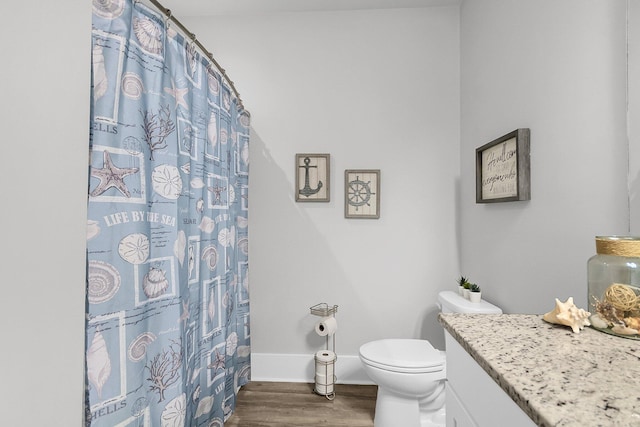 bathroom featuring hardwood / wood-style flooring, vanity, curtained shower, and toilet