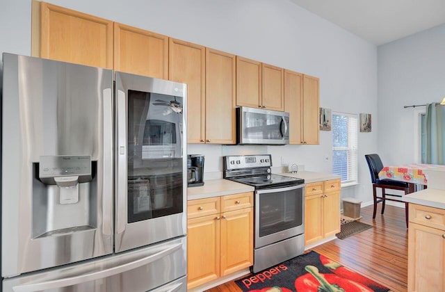 kitchen featuring stainless steel appliances, light brown cabinets, and light countertops